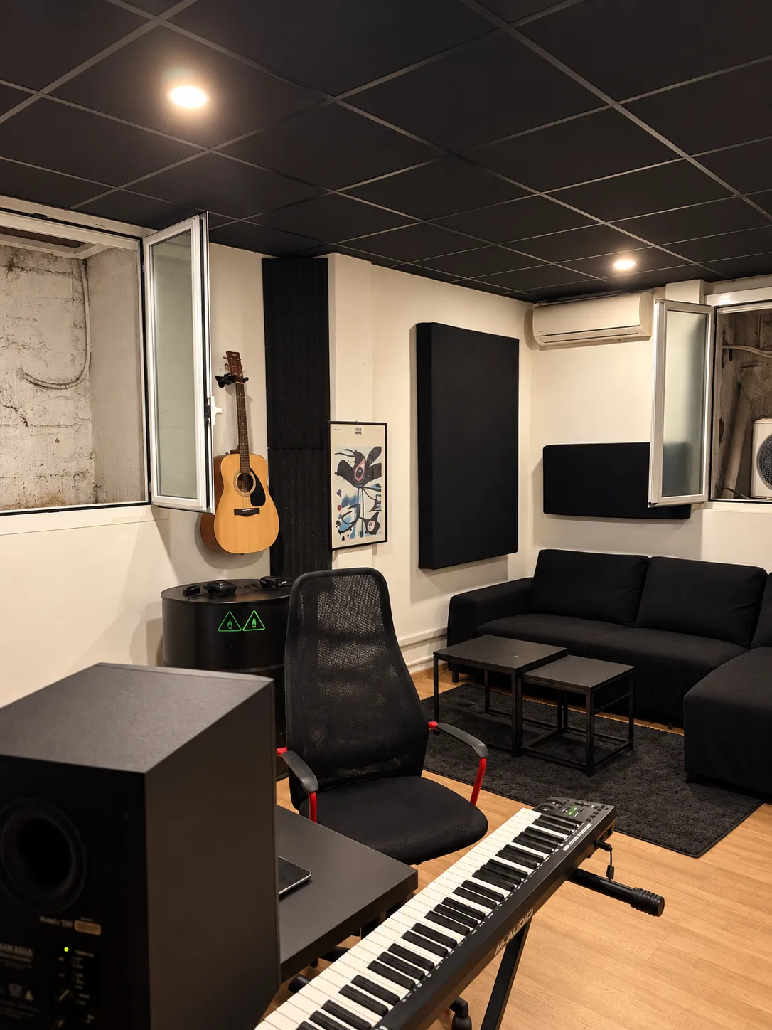 La regia con tastiera, monitor, chitarra e divano